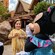 A child standing between Mickey Mouse and Minnie Mouse dressed in tropical attire outdoors