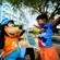 A child smiling in excitement as they greet Goofy while sitting near the pool at Disney’s Beach Club Resort