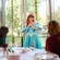 Dos Visitantes sentados en una mesa mientras saludan a la Princesa Ariel durante Disney Princess Breakfast Adventures