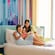 A mother and her 2 daughters sitting on a bed inside a hotel bedroom at The Villas at Disneyland Hotel