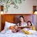A mother reading to her 2 children in bed at Disney’s Grand Californian Hotel & Spa