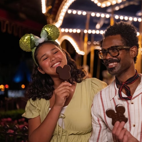3 Guests with Mickey Cookie Pops near the Prince Charming Regal Carrousel