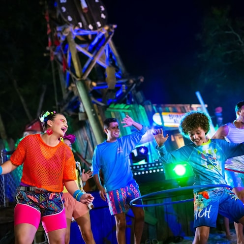 Guests engaged in Hula dancing during a DJ bash at Disney H2O Glow After Hours at Disney’s Typhoon Lagoon water park