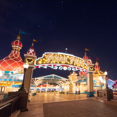 The illuminated entrance to Pixar Pier at night.