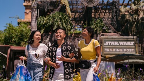 A family of 4 dining at a table in Paseo with a view of Disney Downtown District