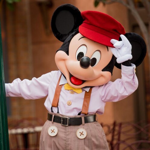  Mickey Mouse inclina su sombrero mientras se encuentra junto a Buena Vista Street