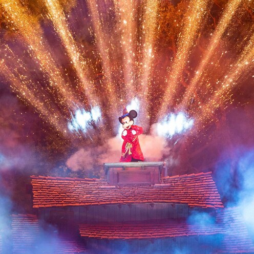 Mickey Mouse posa con luces detrás de él durante Fantasmic
