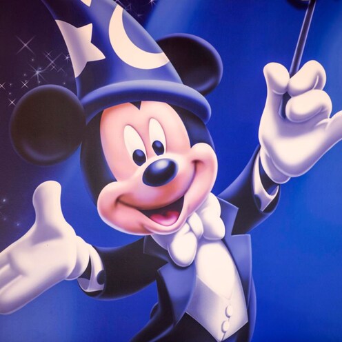Un retrato de Mickey Mouse con sombrero de mago, sosteniendo un bastón de dirección en Mickey's PhilharMagic