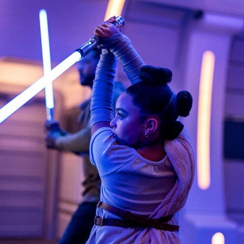 A young Guest wields a lightsaber in a class