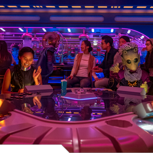 Various Guests play games and interact with Characters from foreign planets in a lounge aboard the Halcyon starcruiser