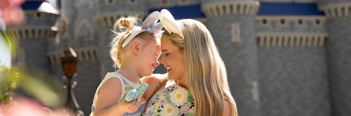  A mother and daughter touching noses and smiling in front of Cinderella Castle at Magic Kingdom park