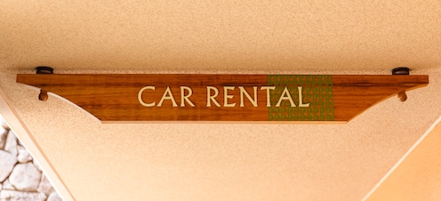 A wooden sign that reads Car Rental