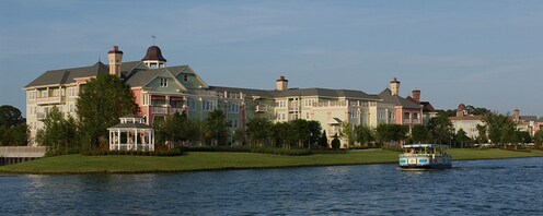 Una embarcación abierta navegando junto al Disney’s Saratoga Springs Resort and Spa de estilo victoriano
