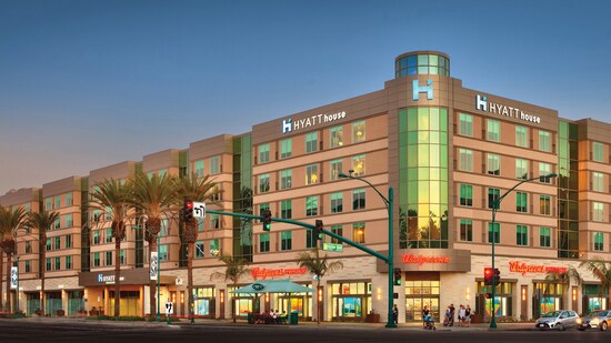 This room features a contemporary dresser, lamp, night stand and modern art hanging above 2 double beds