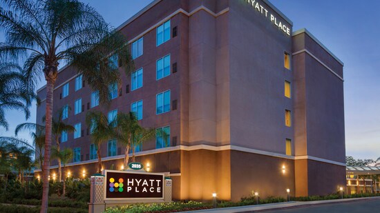 The exterior of Hyatt Place at Anaheim Resort/Convention Center at night surrounded by palm trees