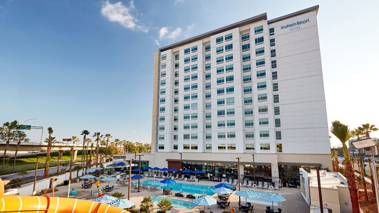 Anaheim Resort Suites hotel exterior with pool area featuring waterslides and striped umbrellas