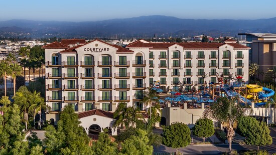 The exterior of Courtyard by Marriott Anaheim Theme Park featuring a large pool area