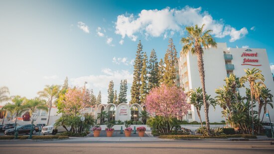 The exterior of the Howard Johnson Anaheim Hotel and Water Playground with palm trees in the landscape