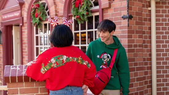 Dos Visitantes con sudaderas navideñas de Walt Disney World Resort y una diadema con orejas de menta de Mickey Mouse