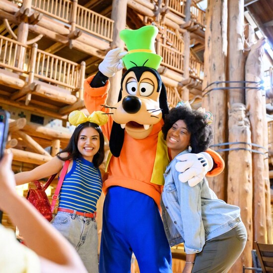 Goofy y 2 Huéspedes posando para una foto en Disney’s Wilderness Lodge