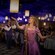 In a dinner show, Rapunzel admires a hanging lantern while Guests and musicians look on