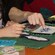 The hand of an older woman pointing out a variety beads to a child
