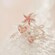 Tres anillos de joyería con centros con forma de estrella de mar, corazón y círculo, todos dispuestos sobre una superficie texturizada