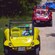 A man drives a roofless beach buggy ahead of other buggies