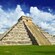 An ancient Mayan pyramid with grass and trees