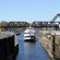 A triple deck tour boat filled with passengers sailing into a canal