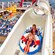 Two children in an inflatable raft propelling through the AquaDuck waterslide above the pool area