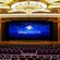 A spacious theater with a large stage and a high curtain