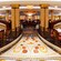 A marble entryway with a royal crest leads to a lavish dining area with chandeliers, at Royal Palace restaurant