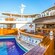 An outdoor bar is on a deck next to a large swimming pool