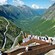 An observation deck looks out to a highway zigzagging across a verdant valley