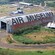 Airplanes and a large hanger near outlying buildings