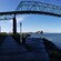 A bridge over a body of water near street lamps and a dock