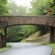 A stone bridge stretching over a forest road