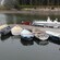 Several small boats docked in waters bordered by trees and historic coastal architecture
