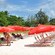 Guests relax on some of the available chaise lounges with umbrellas, shading them from the sun