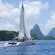 A catamaran carries passengers across the ocean toward mountains