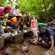 A guide shows his group something interesting in the water of a stream