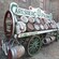 A sign reading Carlsberg Pilsner sits above a beer wagon filled with wooden kegs