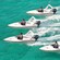 Four, single-seat power boats in a V formation on the ocean