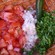 A jalapeno pepper and chopped tomato, onion and cilantro in a terracotta bowl