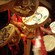 A young boy plays a hand held drum along side a line of drummers in costumes