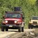A caravan of jeeps traveling on a leafy mountain road