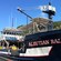 A sign on the side of a large fishing boat identifies it as the Aleutian Ballad