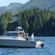 Three men fish off the back of a motor boat