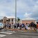 Una multitud reunida alrededor de una exhibición sobre historia en una plaza